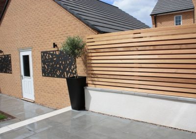 Bespoke garden wall constructed from block and white render with horizantal cedar battens for our Langford clients.
