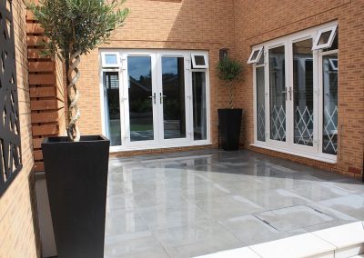 A porcelain terrace with bullnose step leading to the lawn part of the garden in our Langford project.