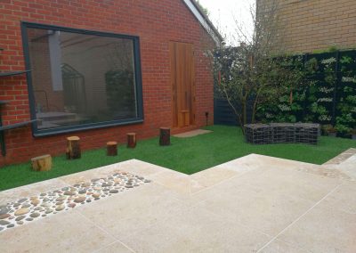 A porcelain terrace with step down onto a small lawn in our Stotfold garden project.