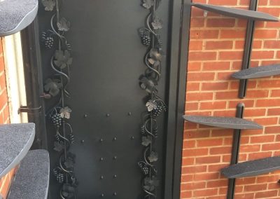 A bespoke steel garden gate with beautiful fruit and vine detailing.