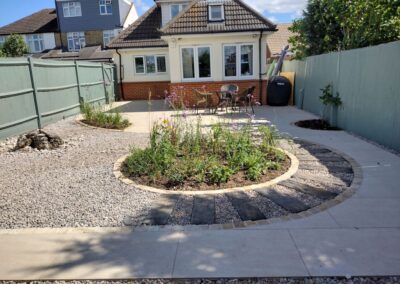 An Upper Caldecote garden project with porcelain paved terrace with round border feature.