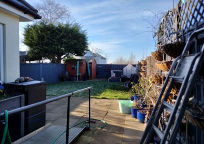 Lawn with paving and sheds before garden transformation.