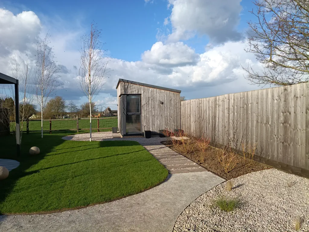 Garden office with blue sky and fluffy clouds.